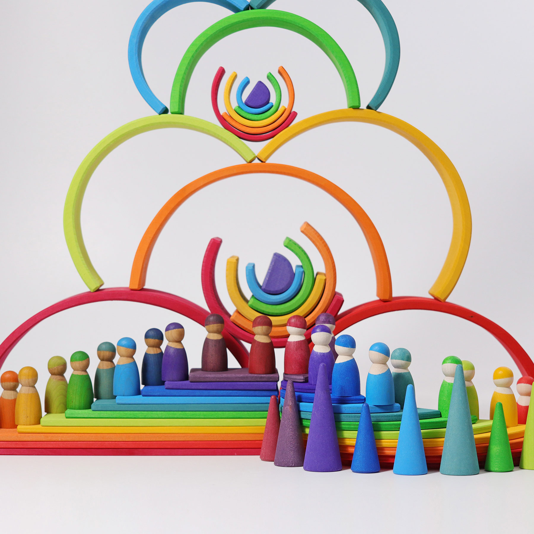 ein großer Turm aus Regenbogenhälften mit Figuren am Boden alles in Regenbogenfarben nahansicht fokussiert auf die Figuren