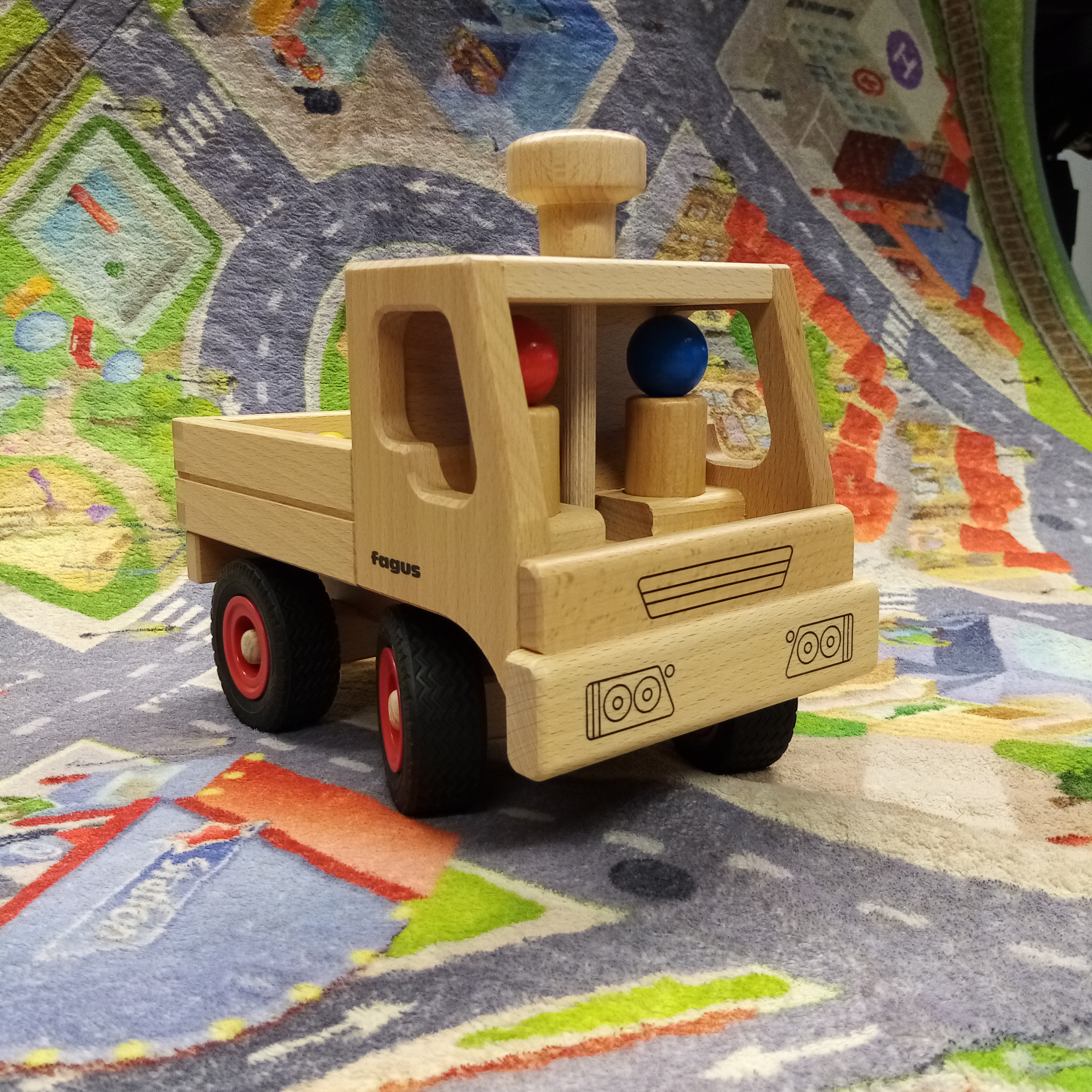 Lenkbarer fagus Unimog von aus Buchenholz mit zwei Holzspielfiguren. 