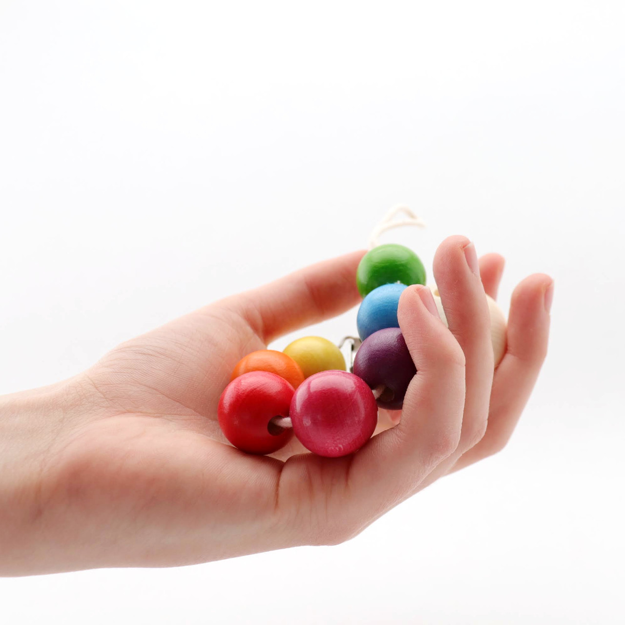 Schnullerkette regenbogenfarben in einer Hand