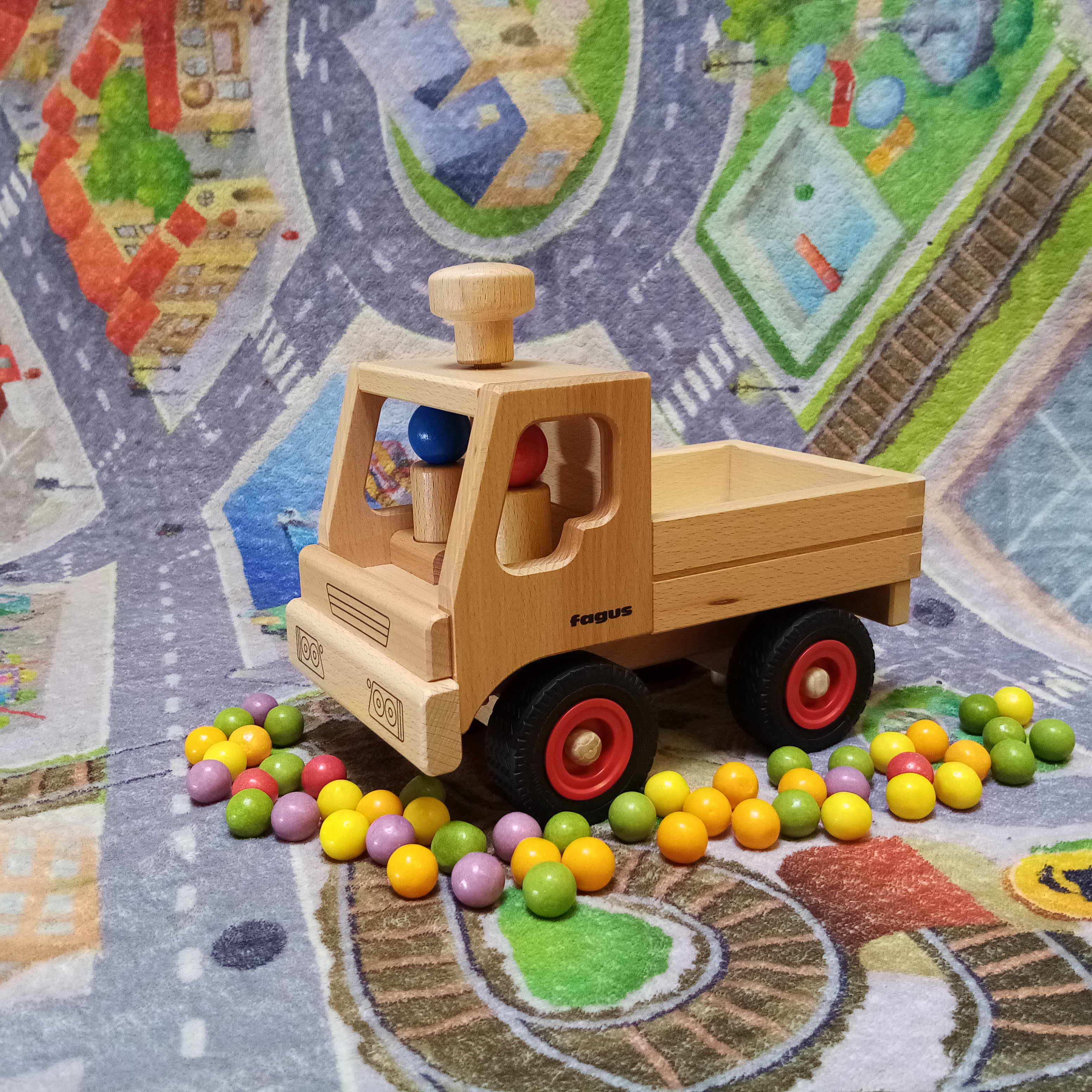 Lenkbarer fagus Unimog von aus Buchenholz mit zwei Holzspielfiguren. 