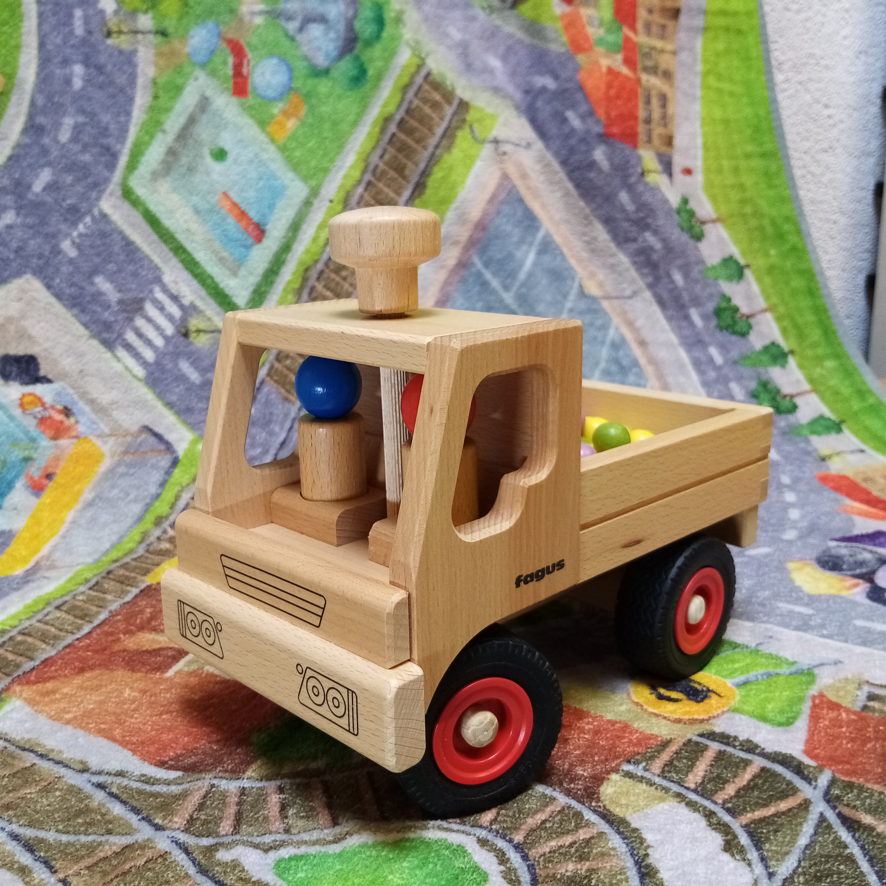 Lenkbarer fagus Unimog von aus Buchenholz mit zwei Holzspielfiguren. 