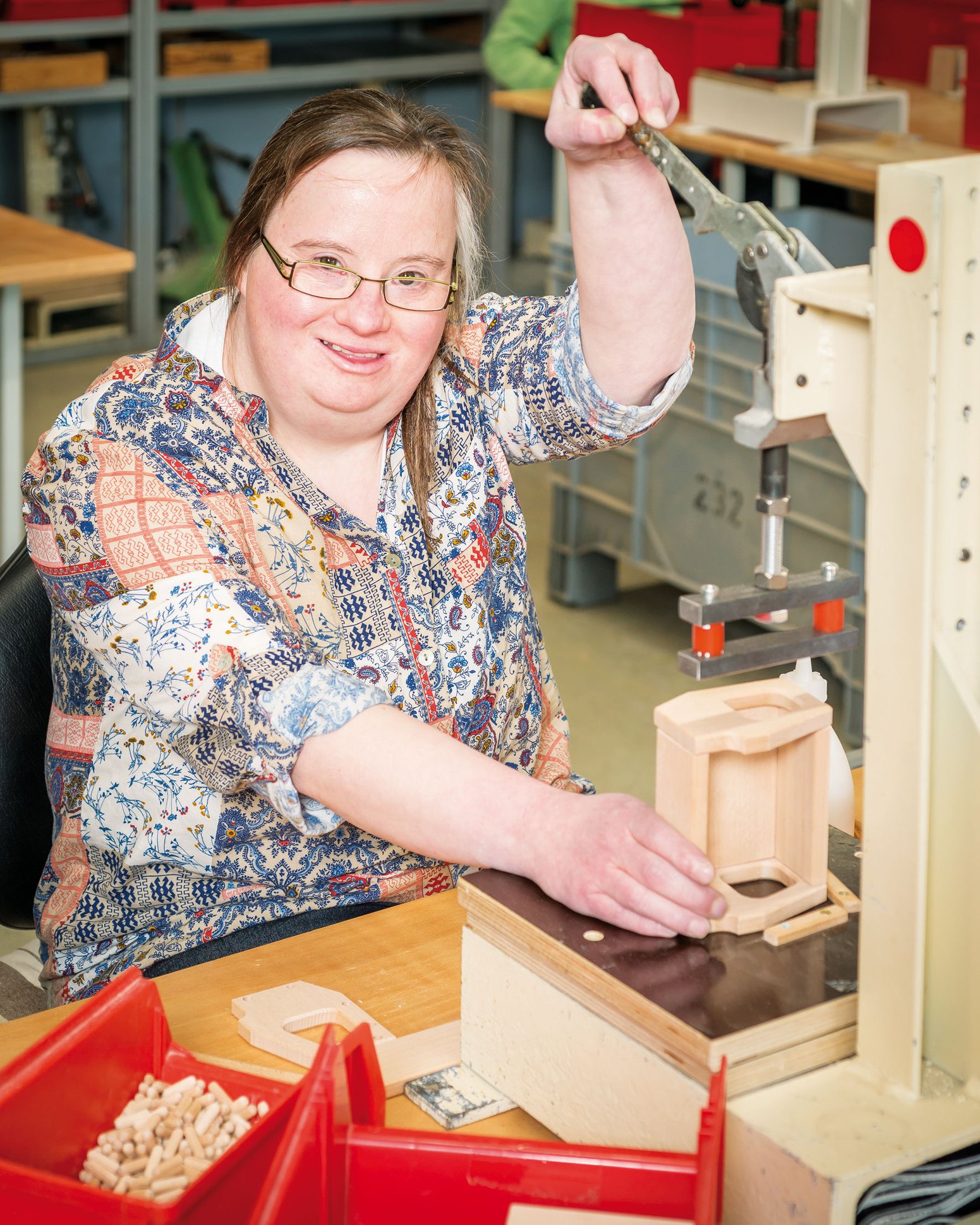 Eine Frau die an einem Werkstück arbeitet